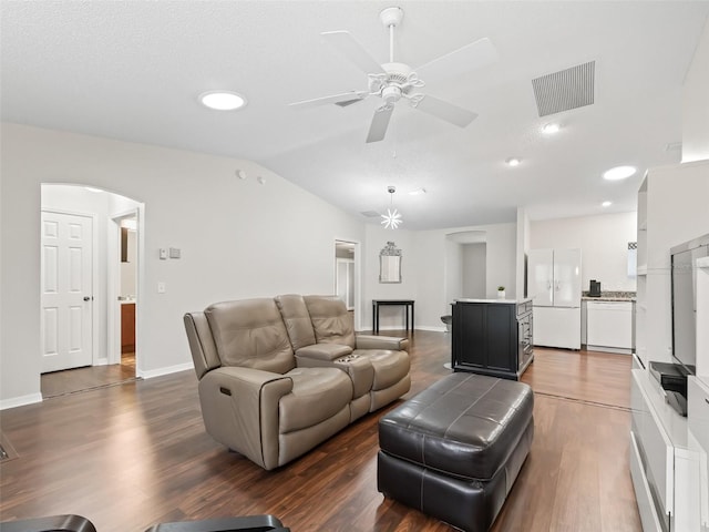 living area with arched walkways, dark wood-style flooring, lofted ceiling, visible vents, and ceiling fan