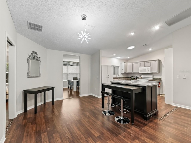 kitchen with white appliances, visible vents, arched walkways, a center island, and light countertops