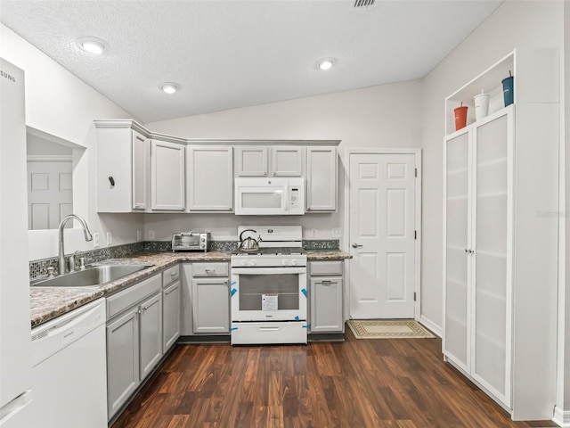 kitchen with gray cabinets, white appliances, a sink, and vaulted ceiling