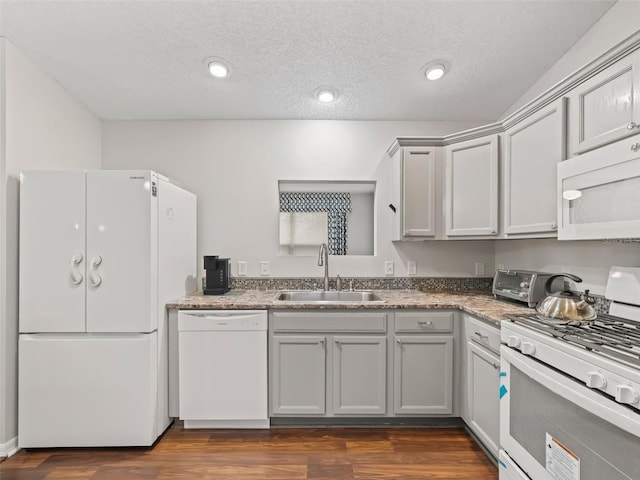 kitchen featuring white appliances, a toaster, dark wood-style floors, gray cabinets, and a sink