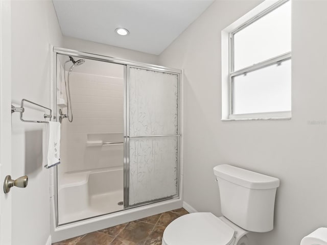 full bath with toilet, a stall shower, and tile patterned floors