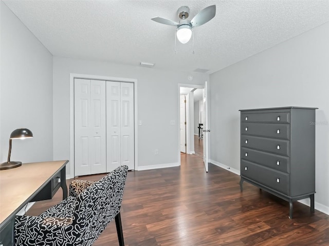 office space featuring a ceiling fan, dark wood-style flooring, a textured ceiling, and baseboards