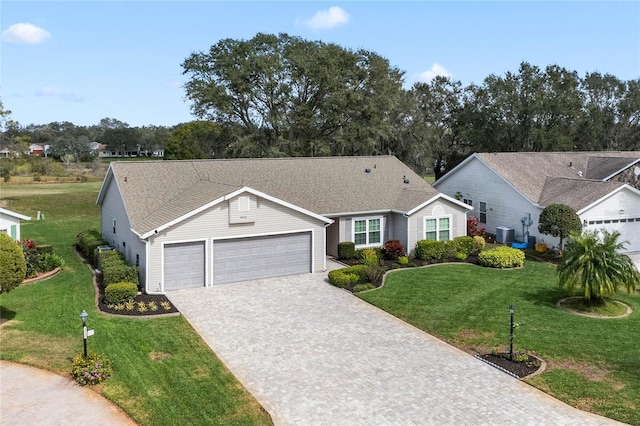 ranch-style home featuring a garage, decorative driveway, and a front yard