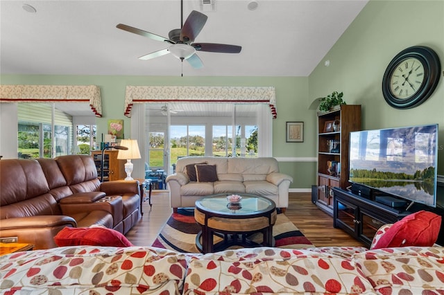 living area with a ceiling fan, vaulted ceiling, and wood finished floors