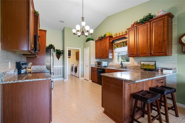 kitchen featuring visible vents, dark stone counters, brown cabinetry, decorative light fixtures, and stainless steel appliances