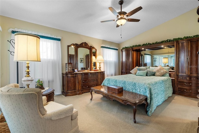 bedroom featuring light carpet, ceiling fan, multiple windows, and vaulted ceiling