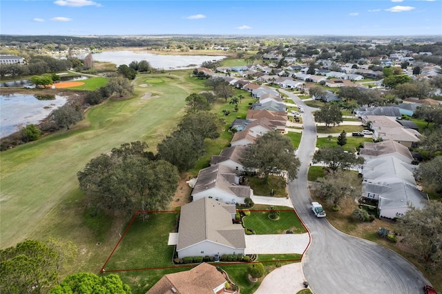 drone / aerial view featuring a residential view, view of golf course, and a water view