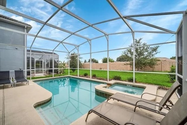 view of pool with a patio area, glass enclosure, a pool with connected hot tub, and a fenced backyard