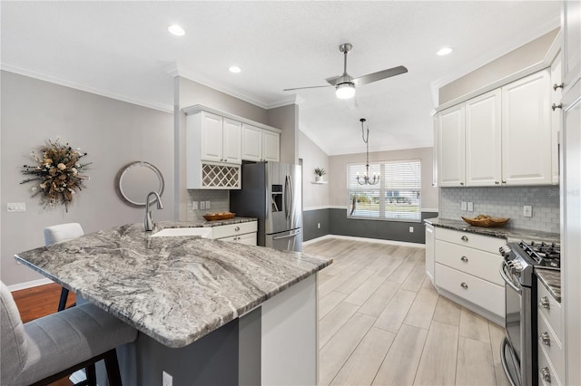 kitchen featuring white cabinets, a breakfast bar area, stainless steel appliances, and a sink