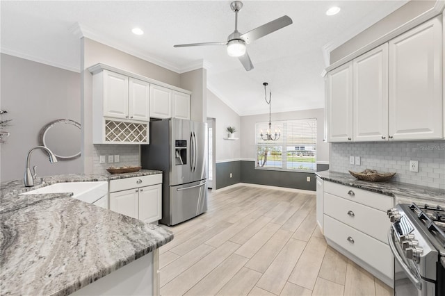 kitchen featuring appliances with stainless steel finishes, white cabinetry, a sink, and light stone counters