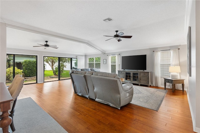 living area featuring a wealth of natural light, light wood-type flooring, and visible vents