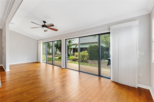 spare room featuring ornamental molding, a ceiling fan, light wood-style flooring, and baseboards