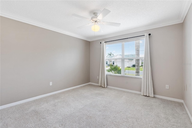 spare room with ornamental molding, ceiling fan, a textured ceiling, and baseboards