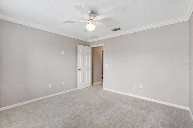 spare room featuring light carpet, visible vents, ceiling fan, ornamental molding, and a textured ceiling