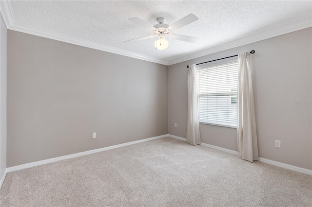 spare room featuring ceiling fan, ornamental molding, a textured ceiling, and light colored carpet