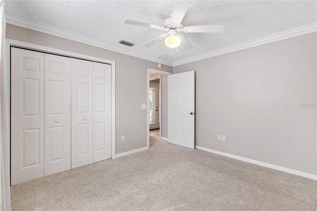 unfurnished bedroom featuring a textured ceiling, visible vents, a closet, and light colored carpet