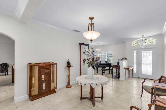 entrance foyer with arched walkways, crown molding, visible vents, and a notable chandelier