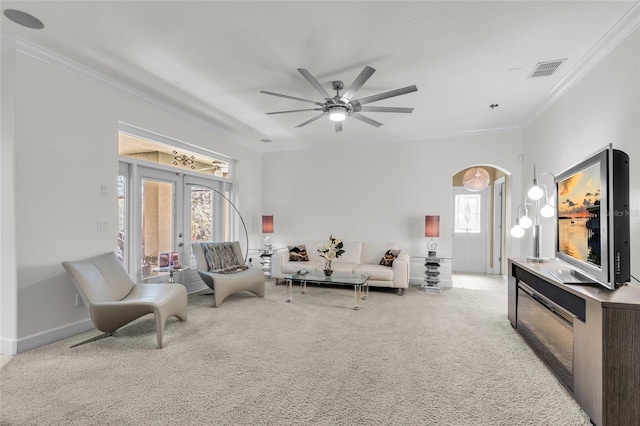 living room featuring arched walkways, french doors, crown molding, light colored carpet, and visible vents