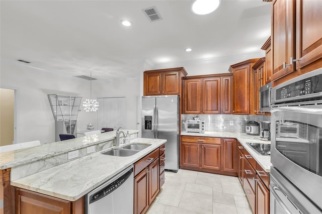 kitchen with visible vents, backsplash, appliances with stainless steel finishes, a kitchen island with sink, and a sink