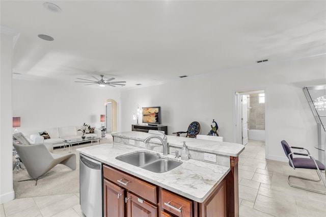 kitchen with stainless steel dishwasher, arched walkways, open floor plan, and a sink