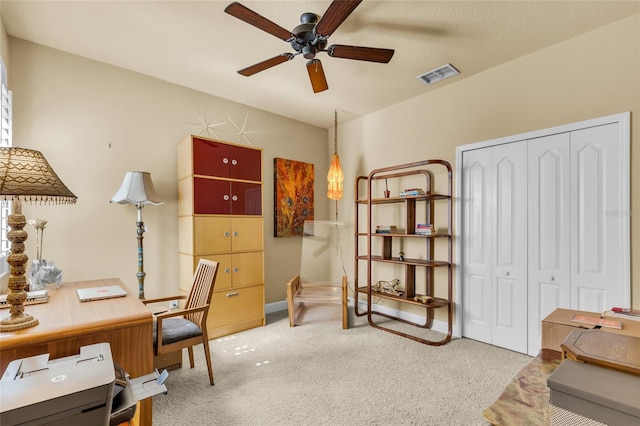 office featuring light carpet, visible vents, and a ceiling fan