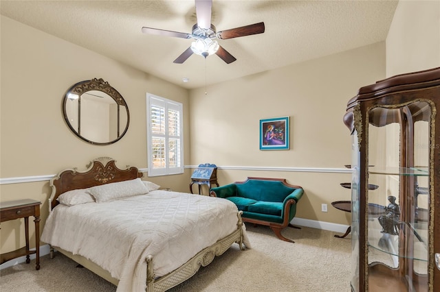 carpeted bedroom with ceiling fan, baseboards, and a textured ceiling