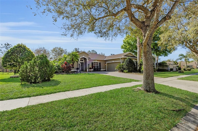 view of front of home with a garage, concrete driveway, a front lawn, and stucco siding