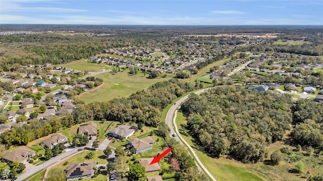 drone / aerial view featuring a wooded view and a residential view