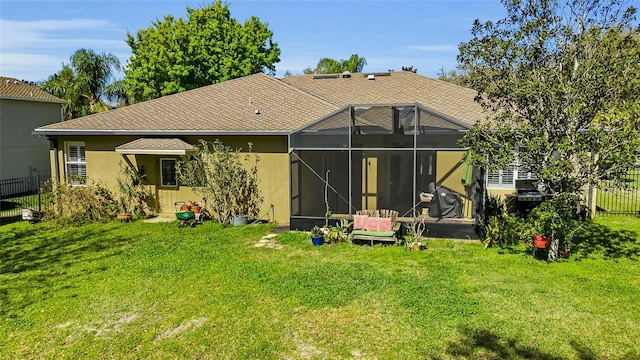 rear view of property with a lanai, a lawn, fence, and stucco siding