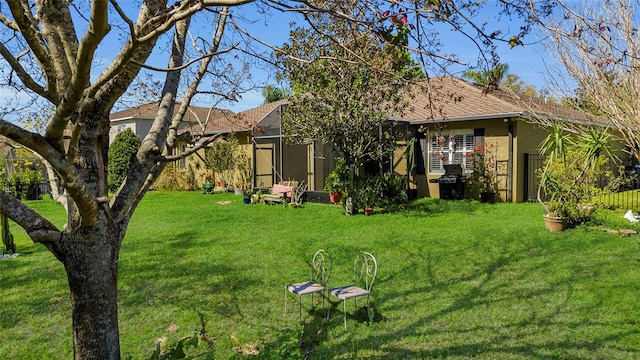 back of house with a lawn and stucco siding