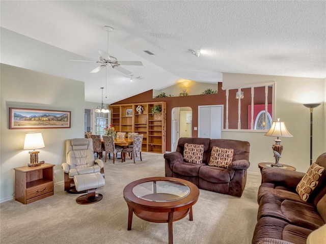 living room featuring light carpet, visible vents, arched walkways, lofted ceiling, and a textured ceiling