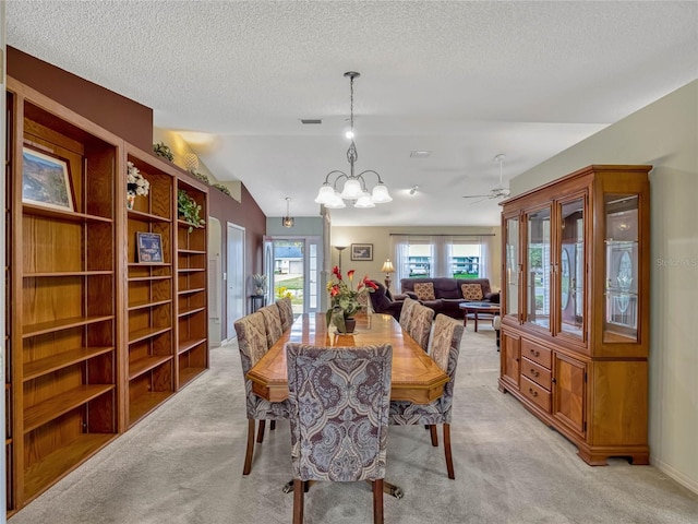 dining area with a textured ceiling, a notable chandelier, light carpet, visible vents, and vaulted ceiling