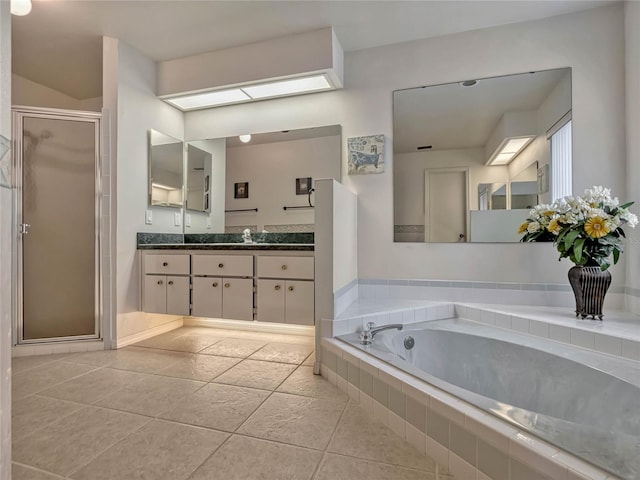 full bath featuring a stall shower, a skylight, tile patterned floors, vanity, and a bath