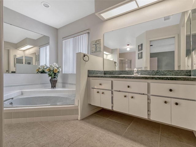 full bath with a stall shower, tile patterned flooring, a bath, and vanity