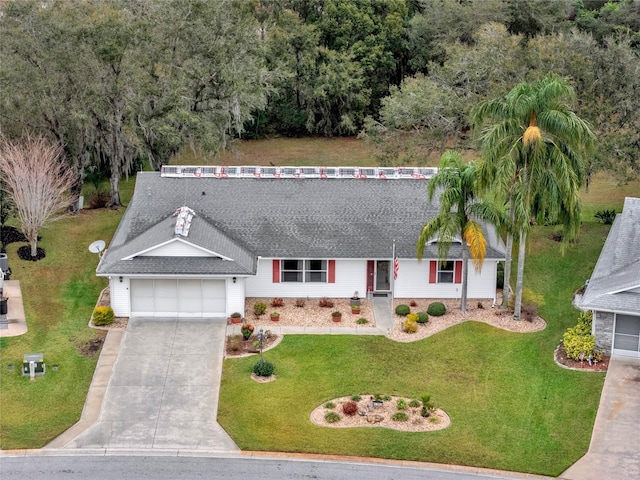 view of front of property with driveway, a shingled roof, an attached garage, and a front yard