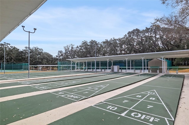 surrounding community with fence and shuffleboard