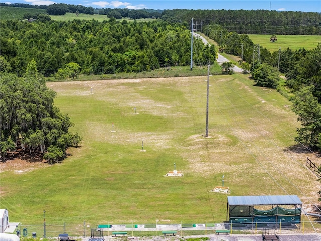 birds eye view of property featuring a rural view and a wooded view