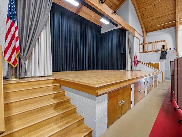 interior space with vaulted ceiling, stairway, wood ceiling, and concrete flooring