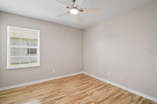 empty room featuring a ceiling fan, baseboards, and light wood finished floors