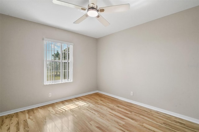 spare room featuring ceiling fan, light wood-type flooring, and baseboards