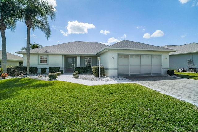 ranch-style house with a garage, a front lawn, decorative driveway, and stucco siding