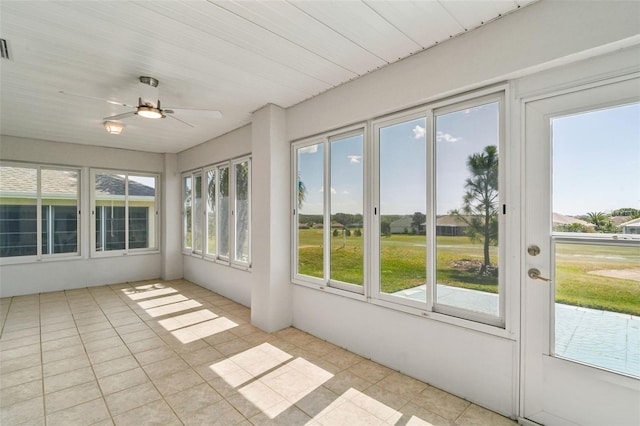 unfurnished sunroom featuring visible vents and ceiling fan