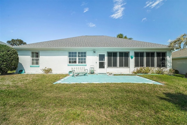 back of property featuring a yard, roof with shingles, a patio, and stucco siding