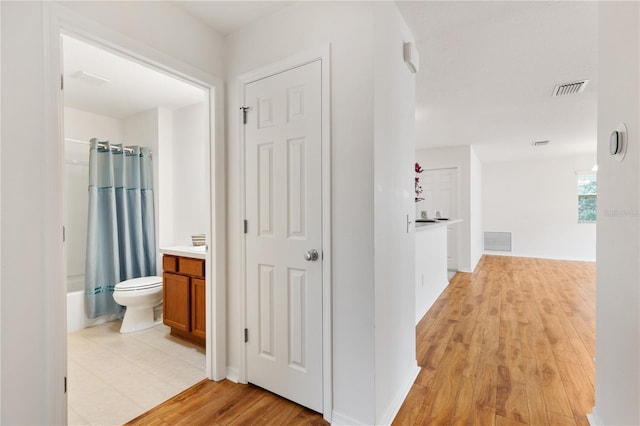 corridor with light wood-style flooring and visible vents