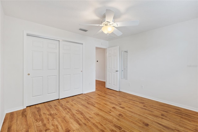 unfurnished bedroom featuring visible vents, baseboards, ceiling fan, light wood-type flooring, and a closet