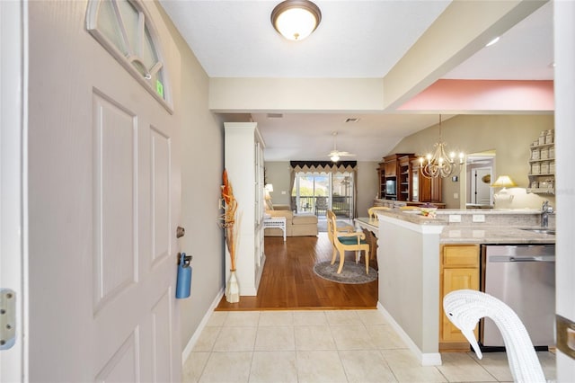 interior space with light tile patterned floors, baseboards, vaulted ceiling, and an inviting chandelier