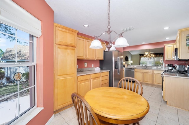 kitchen featuring an inviting chandelier, appliances with stainless steel finishes, and light brown cabinetry