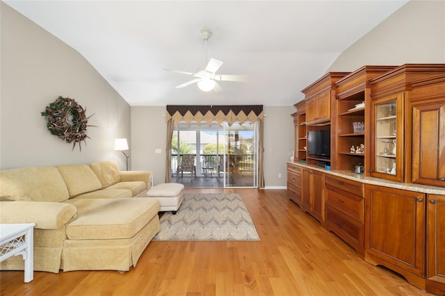 living room with lofted ceiling, light wood-style flooring, and a ceiling fan