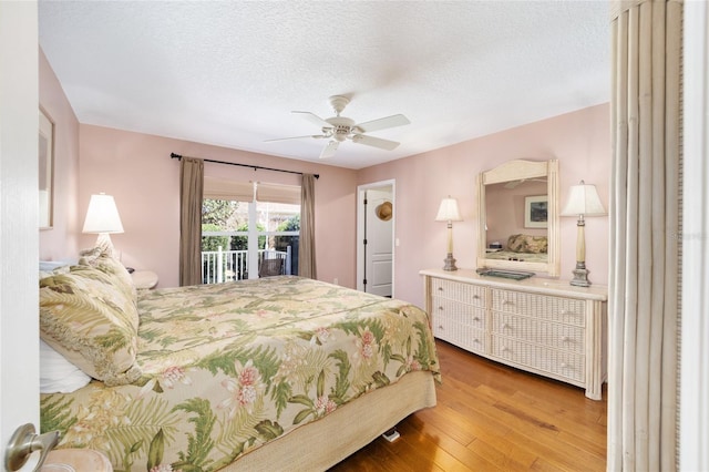 bedroom with a textured ceiling, access to outside, wood finished floors, and a ceiling fan