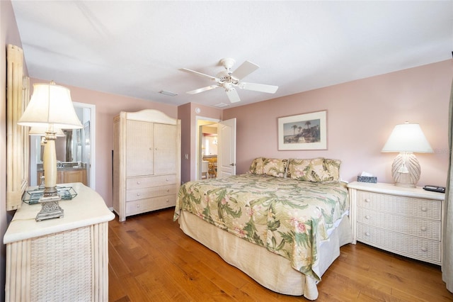 bedroom with a ceiling fan, visible vents, and wood finished floors